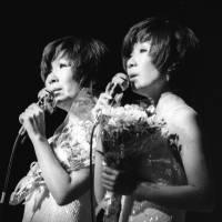 Yumi Ito (right) and Emi Ito of the twin pop duo Peanuts appear on stage in 1975. | KYODO