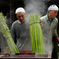 Men boil marijuana plants to extract hemp fiber at the nation\'s largest legal marijuana farm in Kanuma, Tochigi Prefecture, on Tuesday. | REUTERS