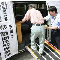 An elderly man enters van believed to be the nation\'s first mobile polling booth, in Hamada, Shimane Prefecture. Early voting for the July 10 Upper House election began last week. | KYODO