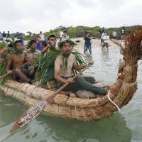 One of the two boats created to replicate part of a hypothetical human migration from Taiwan to Okinawa about 30,000 years ago prepares for a 75km journey on Yonaguni Island in Okinawa Prefecture Sunday, before they arrive at their destination, Iriomote Island, on Monday. | KYODO