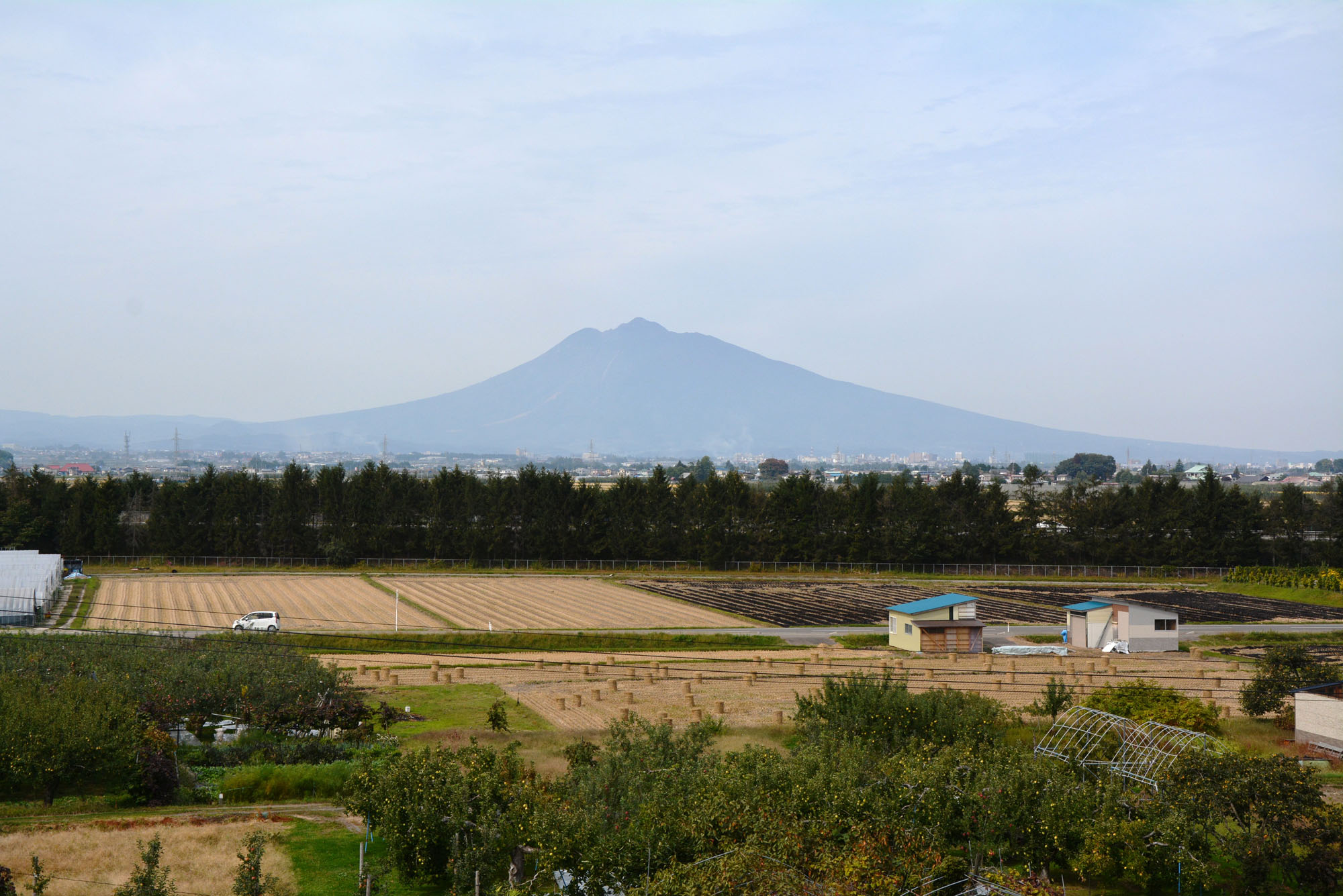 Faded backdrop: Mount Iwaki, a volcano known for its Mount Fuji-like shape, rises above the farms of Tsugaru. | MOMOKO KATO
