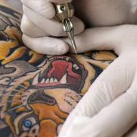 Sharp lines: Tattoo artist Horizaru inks a tiger charging over the right shoulder of a client. | KIT NAGAMURA
