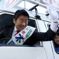 White van man: Tokyo No. 20 district representative Seiji Kihara waves from a vehicle during his successful bid for re-election in December 2014. 	            Bloomberg | BLOOMBERG