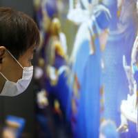 Pixel perfect: A visitor examines a 4K television at a tech exhibition in Tokyo. The difference  between full HD and 4K quality is only really noticeable on TV screens of at least 55 inches. | BLOOMBERG