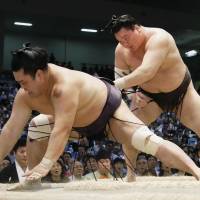 Yokozuna Hakuho overpowers Myogiryu on Saturday at the Nagoya Grand Sumo Tournament. | KYODO