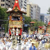 People dressed in historical garb parade through Kyoto on Sunday as part of the famed Gion Matsuri. The festival, dating from 869, is one of the oldest in Japan. | KYODO
