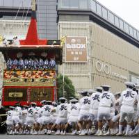 Participants pulling one of the 23 giant floats featured in the month-long Gion Matsuri change its direction at an intersection in Kyoto as the festival approaches its climax on Sunday. | KYODO