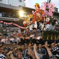 People race with a traditional Japanese float through Kushida Shrine during the Hakata Gion Yamagasa festival in Fukuoka Prefecture on Friday. The run marks the climax of the annual celebration. | KYODO