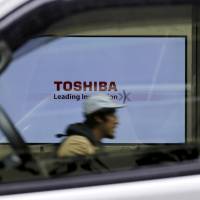 A Toshiba Corp. logo is seen through a car window in Tokyo. The company has been undergoing restructuring. | REUTERS