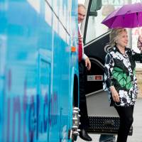 Democratic presidential candidate Hillary Clinton and Democratic vice presidential nominee Sen. Tim Kaine step off the campaign bus in light rain to visit Grandma\'s Cheese Barn in Ashland, Ohio, Sunday. | AP