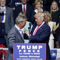 Republican U.S. presidential candidate Donald Trump welcomes Nigel Farage, the former leader of the British U.K. Independence Party, to speak at a campaign rally in Jackson, Mississippi, on Wednesday. | AP