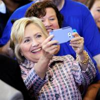 Democratic presidential nominee Hillary Clinton takes a selfie with a supporter Monday after a rally in Omaha, Nebraska. | REUTERS