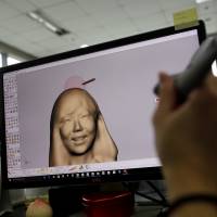 An employee works on 3-D rendering at a specialist printing company in Seoul on Friday. | REUTERS