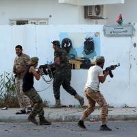 Forces loyal to Libya\'s U.N.-backed Government of National Accord (GNA) hold a position near the central area known as District One on Sunday as they fight Islamic State group jihadis holed up in the coastal city of Sirte, east of the capital Tripoli. | AFP-JIJI