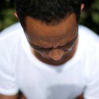 Mose, a 26 year-old from Eritrea, sits during an interview with Reuters in Rome Aug. 5. | REUTERS