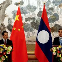 Laos Foreign Minister Saleumxay Kommasith (left) and his Chinese counterpart, Wang Yi, hold a news conference after a meeting at the Diaoyutai State Guesthouse in Beijing on Aug. 3. | REUTERS