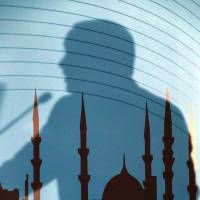 The shadow of Turkish President Recep Tayyip Erdogan falls across a painting of a mosque as he addresses the Turkish Religious Affairs Directorate in Ankara on Wednesday. | AP