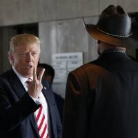 Republican presidential candidate Donald Trump gestures to Milwaukee County Sheriff David Clarke, Jr. as he visits the Milwaukee County War Memorial Center on a campaign stop in Milwaukee Tuesday. | AP
