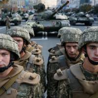 Ukrainian servicemen take part in a rehearsal for the Independence Day military parade in central Kiev on Friday. Putin hints at war in Ukraine, but Russian leader likely seeking diplomatic edge