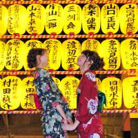 Women in yukata casual kimono laugh in front of orange lanterns at the Mitama Matsuri festival at Tokyo’s Yasukuni Shrine on July 16. Yasukuni Shrine glows in its traditional mid-summer show