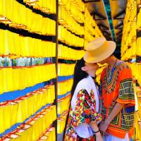 A couple kiss among rows of orange lanterns at the Mitama Matsuri festival at Yasukuni Shrine in Tokyo\'s Chiyoda Ward on July 16. | YOSHIAKI MIURA