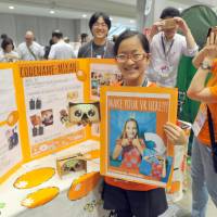Mina Tsuchida, 12, shows off her virtual reality googles at Maker Faire Tokyo 2016 on Sunday. | YOSHIAKI MIURA