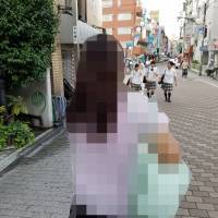 Single mom Kasumi Endo (not her real name), 47, poses on a street in Tokyo’s Ikebukuro district on Aug. 5 after being interviewed by The Japan Times on her double life as an office worker by day and sex worker by night. | TOMOHIRO OSAKI