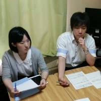 Lawyer Reia Tokuda (left) and social worker Hirofumi Oikawa listen to a woman in the call girl industry discuss her financial problems at a free consultation run by the Fu Terasu project on July 2, in a tiny apartment in Tokyo. | TOMOHIRO OSAKI