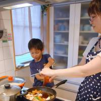 A mother and child prepare a sweet-and-sour pork dish using a ready-to-cook kit at their home in Saitama. | KYDOO