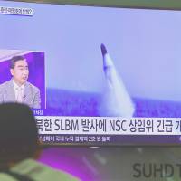 A man watches a television showing footage of an earlier North Korean missile launch, at Incheon Airport, west of Seoul, after North Korea test-fired a submarine-launched ballistic missile Wednesday. | AFP-JIJI
