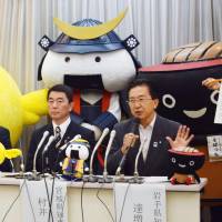Iwate Gov. Takuya Tasso (raising hand) addresses a news conference in Tokyo on Wednesday as Miyagi Gov. Yoshihiro Murai and other municipal officials look on. | KYODO