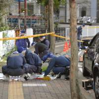 Police officers check the scene Tuesday in the city of Chiba, where a 14-year-old girl was stabbed earlier on the day. | KYODO
