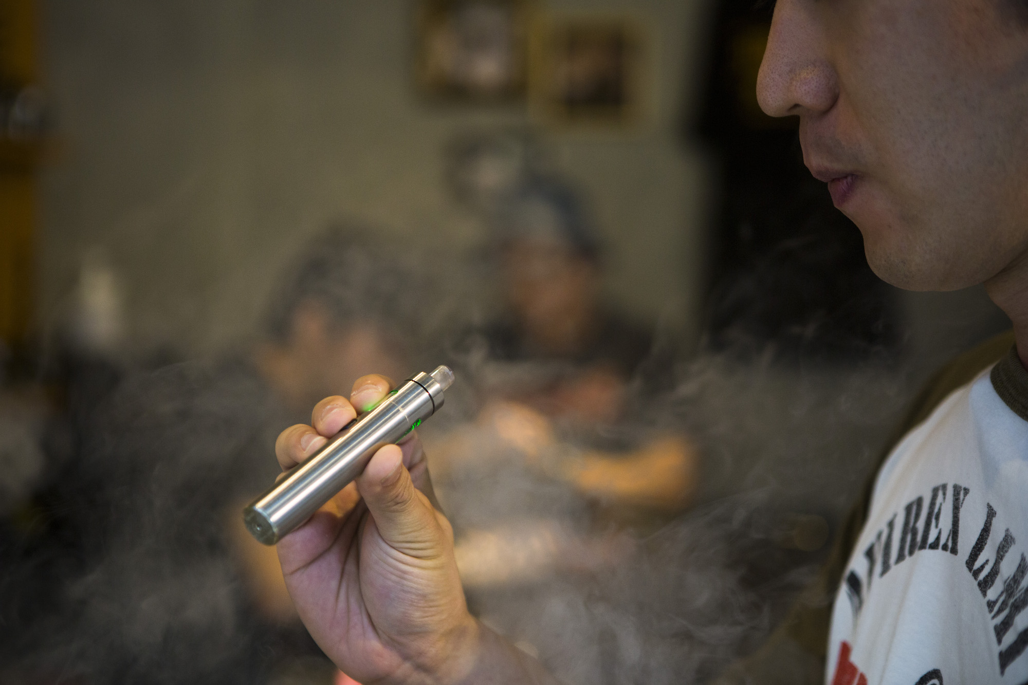 A customer holds a vaporizer at the Vaping Ape store in Shibuya. They sell e-juice for vaping, but are unable to sell liquid containing nicotine.  | BLOOMBERG