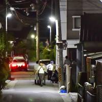Police investigators are seen near site where Yasuhide Mizobata, the suspect of a Monday fatal shooting in the city of Wakayama, was found early Wednesday morning. | KYODO