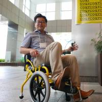 TESS Co. representative director Kenji Suzuki is seen at an event in Tokyo\'s Shinjuku district. Disabled and able-bodied people were invited to try out the wheelchair. | KAZUHIRO KOBAYASHI