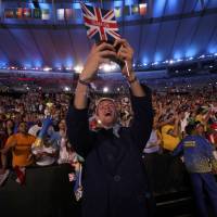 An athlete from Great Britain takes a selfie with fans during the Opening Ceremony for the 2016 Rio de Janeiro Olympics on Friday. | REUTERS