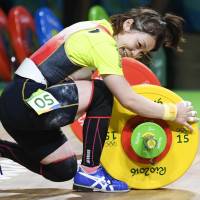 Hiromi Miyake celebrates after her final lift in the women\'s 48-kg weightlifting competition at the 2016 Summer Olympics in Rio de Janeiro on Saturday. Miyake won the bronze medal. | KYODO