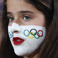 A girl with the Olympic rings painted on her face watches the match between Venus Williams, of the United States, and Belgium\'s Kirsten Flipkens during first round of the women\'s singles tournament at the 2016 Rio de Janeiro Olympics on Saturday. | AP
