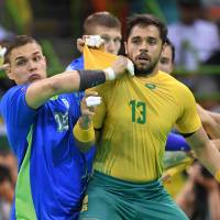 Slovenia\'s pivot Vid Poteko (left) vies with Brazil\'s center back Diogo Kent Hubner during their preliminary contest in men\'s handball at the Rio de Janeiro 2016 Olympics Games at the Future Arena on Tuesday. | AFP-JIJI