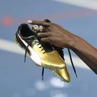 Jamaica\'s Usain Bolt holds up his shoes after winning the men\'s 100-meter final during on Sunday at the 2016 Summer Olympics in Rio de Janeiro. | AP