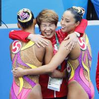 Bronze medalists  Yukiko Inui (right) Risako Mitsui (left) celebrate with their coach, Masayo Imura, after the  synchronized swimming duets technical routine final on Tuesday at the 2016 Rio de Janeiro Games. | KYODO