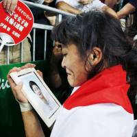 Kaori Icho looks at a picture of her late mother, Toshi, after clinching the fourth straight gold medal of the women\'s freestyle wrestling event on Wednesday at the 2016 Rio de Janeiro Olympics. | KYODO