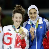 Gold medalist Jade Jones of Britain (second from left) and other medalists pose for photos after the women\'s 57-kg taekwondo competition at the Rio de Janeiro Olympics on Thursday. | AP