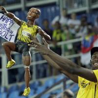 Jamaica\'s Usain Bolt holds a model of himself as he celebrates winning the gold medal in the men\'s 4x100-meter relay final at the Rio Games on Friday. He turns 30 years old on Saturday. | AP