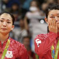 Gold medallists Misaki Matsutomo (left) and Ayaka Takahashi of Japan cry on the podium Thursday in Rio de Janeiro. | REUTERS