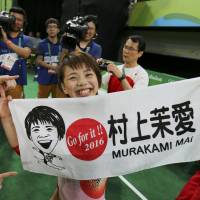 Mai Murakami holds up a banner after the qualification round of the women’s gymnastics competition at the Rio Olympics on Sunday. | REUTERS