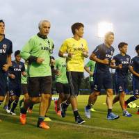 Japan manager Vahid Halilhodzic (second from left) leads his players on a run during a training session on Sunday. | KYODO