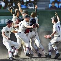 Sakushin Gakuin High School players celebrate their 7-1 win over Hokkai High School in the National High School Baseball Tournament finale on Sunday afternoon at Koshien Stadium. | KYODO