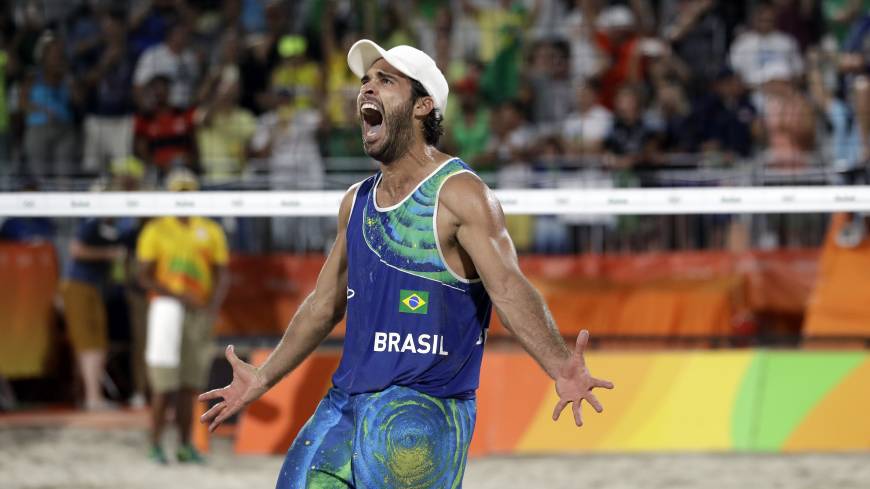 Brazil’s Bruno Oscar Schmidt celebrates after beating the Netherlands during a men’s beach volleyball semifinal match at the Rio Olympics on Tuesday in Rio de Janeiro. Born into hoops, this Schmidt has sand in his soul