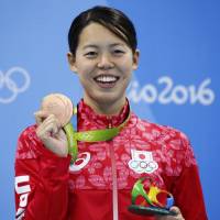 Swimmer Natsumi Hoshi poses with her bronze medal from 200-meter butterfly on Wednesday night. | REUTERS